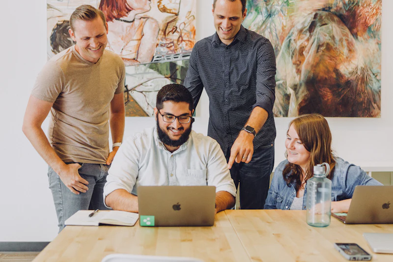 Team overlegt lachend rond een laptop